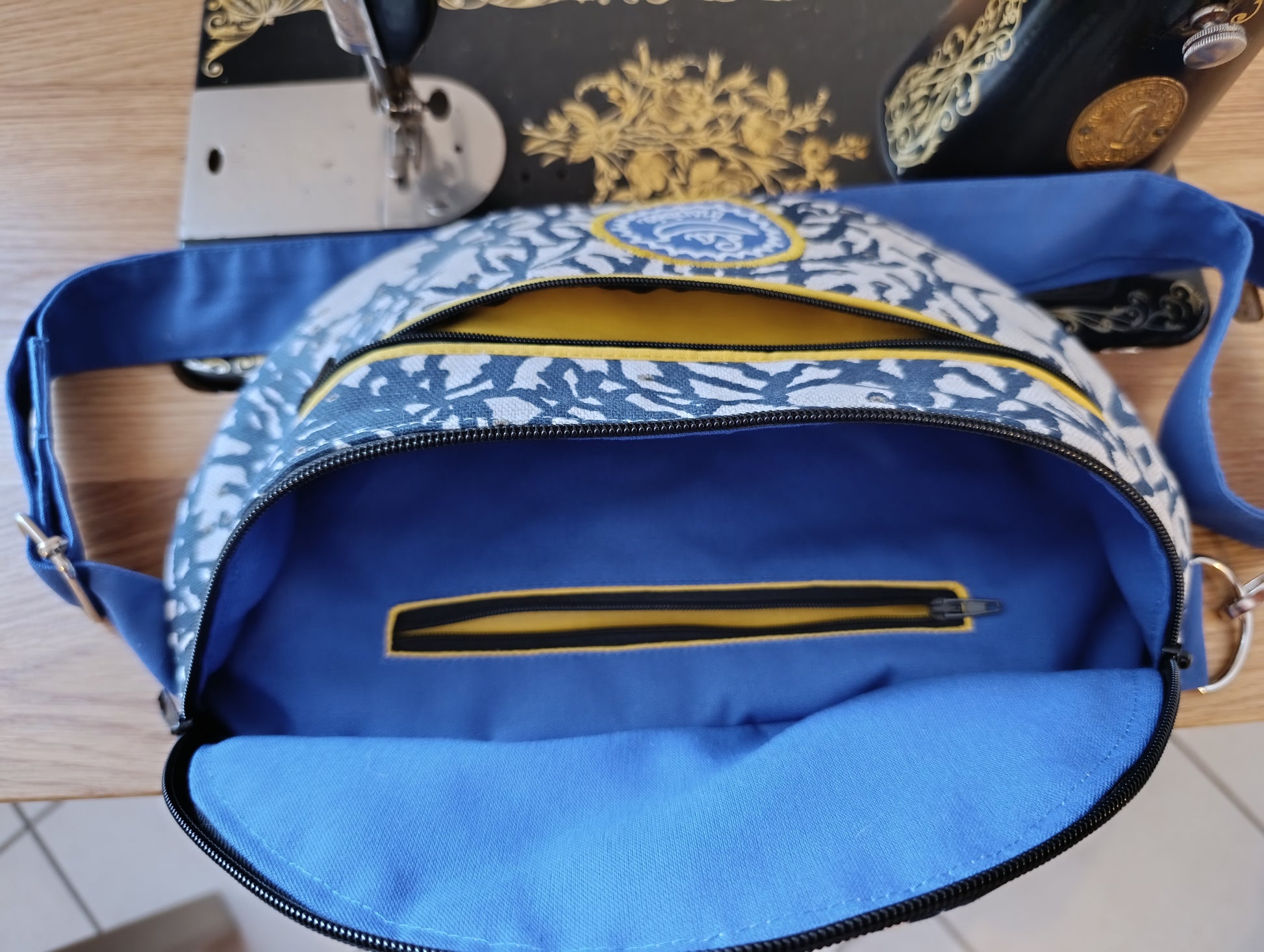 Sac banane La Banane Inspirée motif Corail Solaire, version marine, corail bleu marine sur fond écru, détails jaunes vue intérieure avec poche zippée 