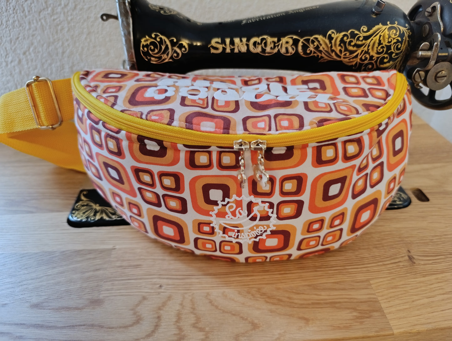 Sac banane La Banane Inspirée motif Ambre Seventies, carrés ambre orange et brun sur fond blanc vue de face 